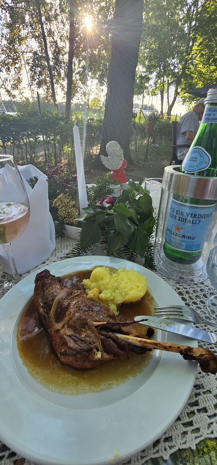 Lammhaxe auf der Terrasse, im Hintergrund die Boote auf der Havel